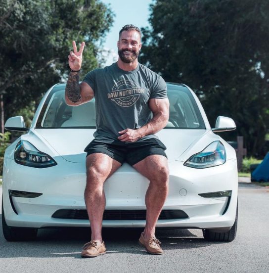 Chris Bumstead con su coche Tesla